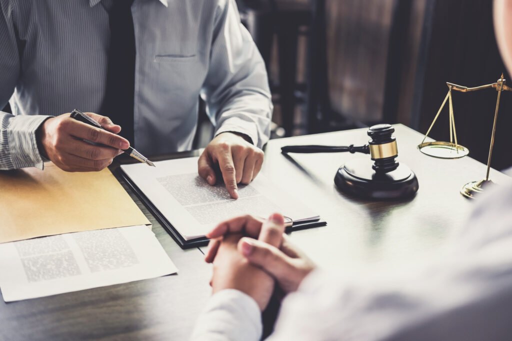 corporategovernance Zwei Personen sitzen an einem Tisch und unterschreiben Papiere